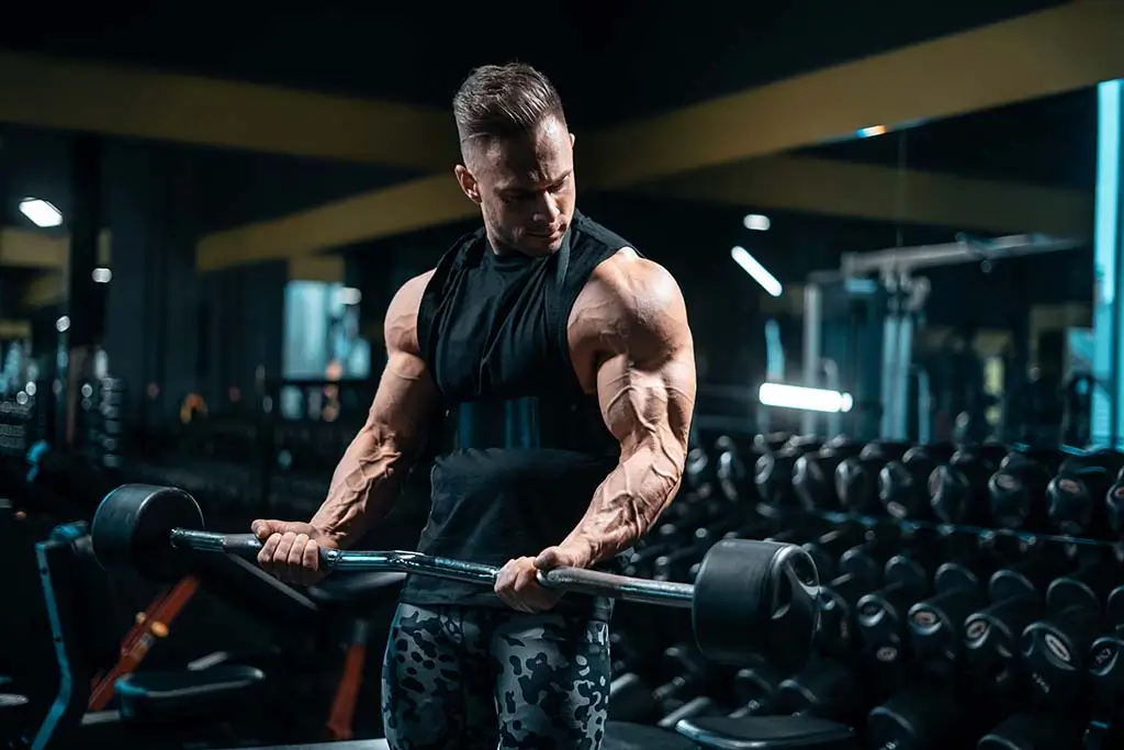 muscular man doing barbell curls